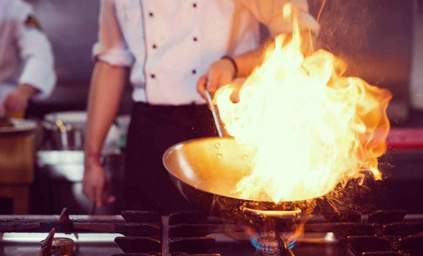 chef-doing-flambe-on-food-PF3STCY